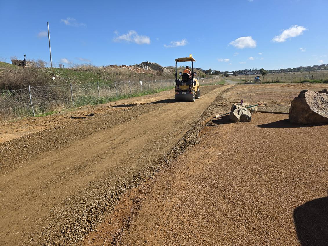 Roller compacting a prepared civil access road base